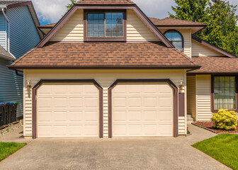 Garage door in luxury house with trees and nice landscape in Summer in Vancouver, Canada, North America. Day time on June 2024.