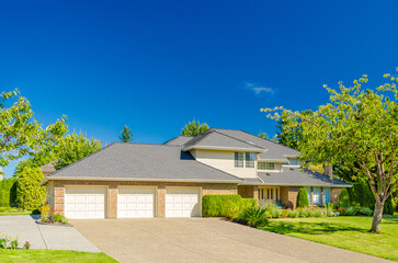 Garage door in luxury house with trees and nice landscape in Summer in Vancouver, Canada, North...