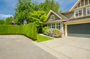 Garage door in luxury house with trees and nice landscape in Summer in Vancouver, Canada, North America. Day time on June 2024.