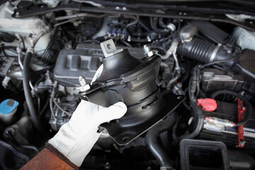 Engine mount component held in auto mechanic hand , Automotive parts concept