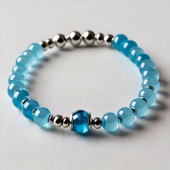 Obraz premium A beautifully crafted bracelet with ocean-colored beads, highlighted by a shimmering central stone.