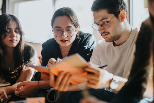A group of students working together on school projects, exchanging ideas and information in a relaxed atmosphere. The image conveys teamwork, collaboration, and focused study in an educational