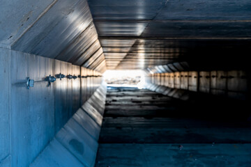 Dramatic Image inside a concrete box culvert under a road for stormwater drainage. 