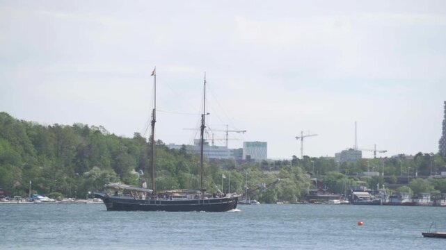 Traditional two-masted sailing ship navigating calm waters near stockholm
