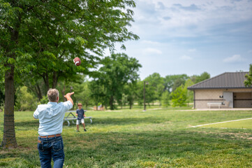 Grandpa playing catch with a football at a park