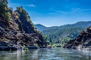 Wild and scenic Rogue River in Southern Oregon with a distant rafter floating. 