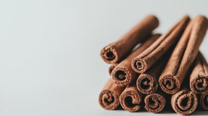 Decorative arrangement of cinnamon sticks stacked on a light background showcasing their natural texture and color