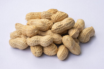 Dried peanuts in closeup on white. Whole and peeled peanuts on white background. Isolated Peanuts.