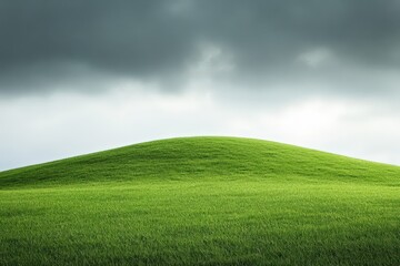 Obraz premium Green rolling hill under a cloudy sky