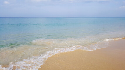 Obraz premium The sea and the sky, waves crashing against the shore, creating sea foam.