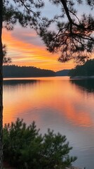 Obraz premium Serene sunset at Lake Ouachita with vibrant colors reflecting on calm waters and silhouettes of pine trees