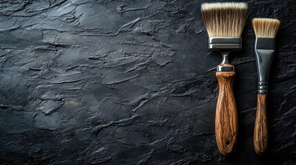 Brushes resting on a textured black surface, ready for the artist\'s touch to bring creativity to life