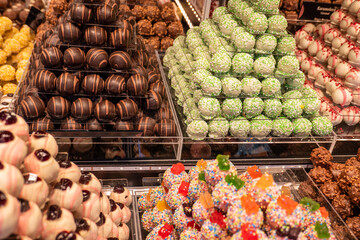 Rows of assorted chocolate treats, featuring vibrant colors and various textures, create an inviting atmosphere.