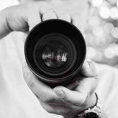 Camera with lens in photographer's hands
