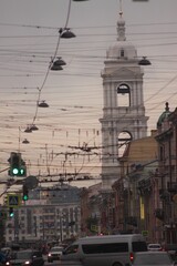 A city street with a tall white tower in the background