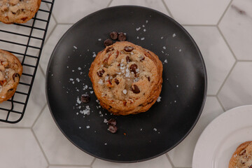 Chocolate cookie stack covered in salt surrounded by other cookies