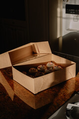 To go box with dozen cupcakes sitting in widow light on counter