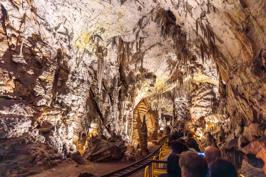 Tourists riding train exploring postojna cave in slovenia