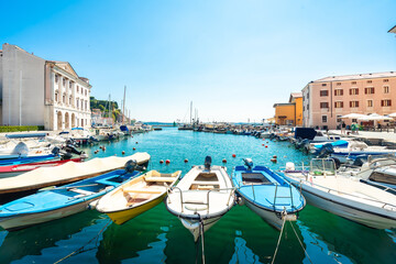 Colorful boats floating gently in piran harbor on a sunny summer day - Powered by Adobe