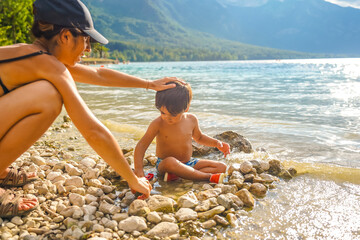 Mother and son playing on the shores of lake bohinj, slovenia