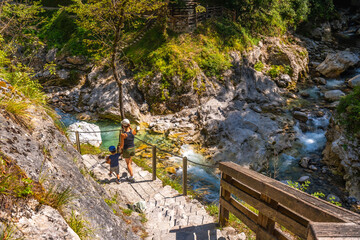 Tourists walking down stone steps at tolmin gorge in slovenia
