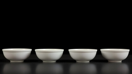 Minimalist White Bowls: Five pristine white bowls stand in a row against a dark backdrop, their smooth curves reflecting the light. A simple yet elegant arrangement.