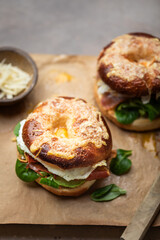bagel grillé gratiné au fromage fourré oeuf au plat, salade, bacon et parmesan