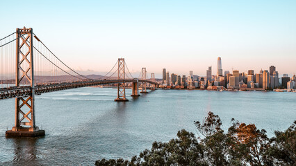 the oakland bay bridge and skyline of san francisco in the morning light