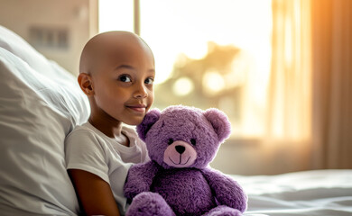 African American Child sick with cancer holding purple teddy bear while sitting on hospital bed in a room. World Cancer Day concept