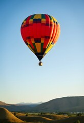 Fototapeta premium Colorful Hot Air Balloon Soaring Over Scenic Landscape