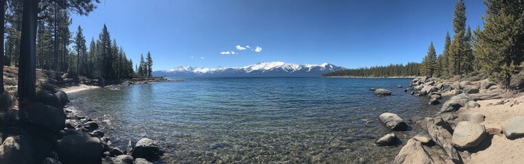 Naklejka premium Deep blue waters of Lake Tahoe reflect the surrounding mountains and trees on a clear summer day
