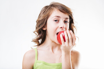 Young girl biting a red apple on white background