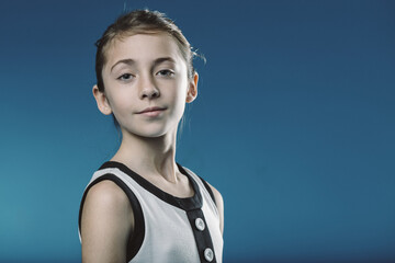 Confident young girl posing against blue background