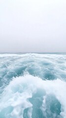 Fototapeta premium Tranquil Ocean Waves with Soft Foam Against a Calm Horizon in a Serene Coastal Landscape Under Overcast Sky