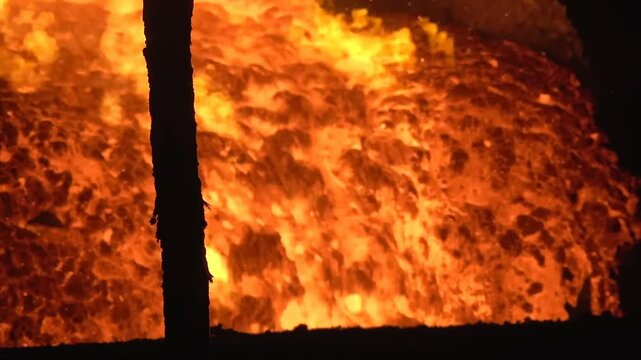 Witness the intense process of smelting metal inside an industrial furnace. High temperatures melt and purify the metal for various uses.