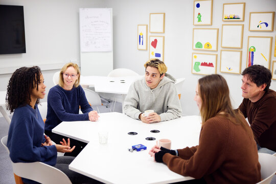 Healthcare workers listening to medical students during discussion in office