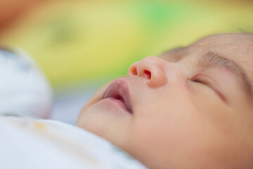 close-up detail of sleeping baby face with mouth and nose open, adorable and cute newborn baby