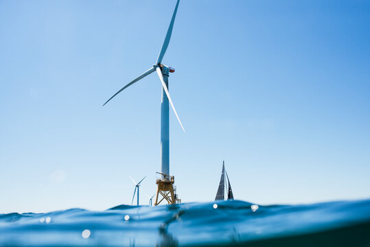Boats sailing by Wind Turbines in New England