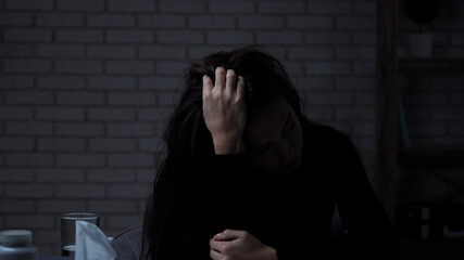 Silhouette of woman suffering mental health issues, sitting at the table, depressed expression,...