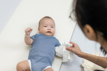 Mum clean baby hand on bed