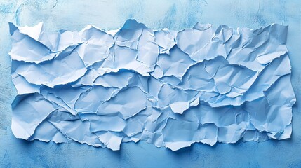 Fototapeta premium Crumpled blue paper resting on a textured surface, showcasing an abstract design with various folds and shadows.