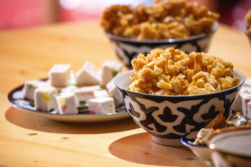 A table with a variety of food, including a bowl of popcorn