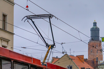 tram in the city with a raised pantograph. tram traction network. electric public transport against...