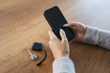 unknown woman hold wireless location accessory token to locate keys