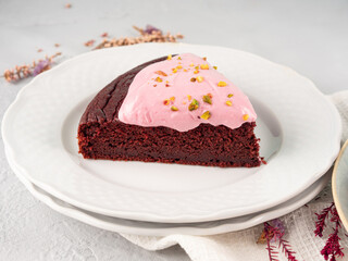 Piece of beetroot chocolate cake with pink cream cheese icing