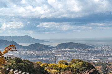 View of the ocean and Mishima city seen from the Mishima Skywalk Bridge with moving clouds in the sky