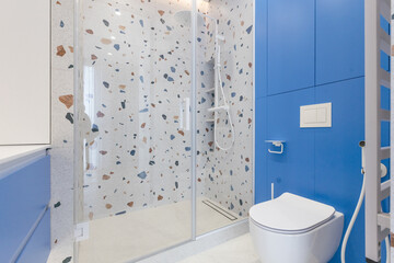 wall hung toilet. white toilet on a gray wall. On the floor tiles imitate wood.