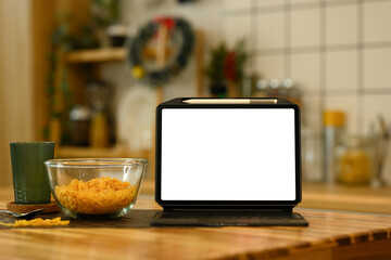 Front view digital tablet with white screen near a bowl of cornflakes on kitchen table