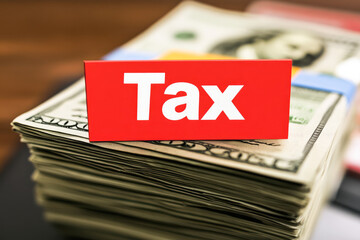 Stack of dollars with tax label signifying financial obligation and revenue