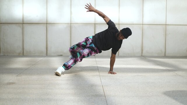 Breakdancer performing freeze move in urban environment